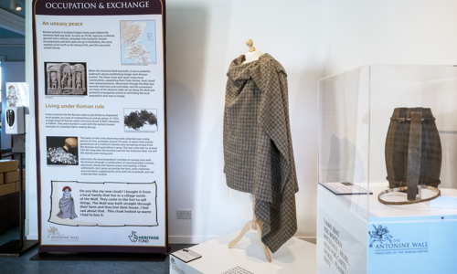 An information board is shown in the background and also a clothing display 